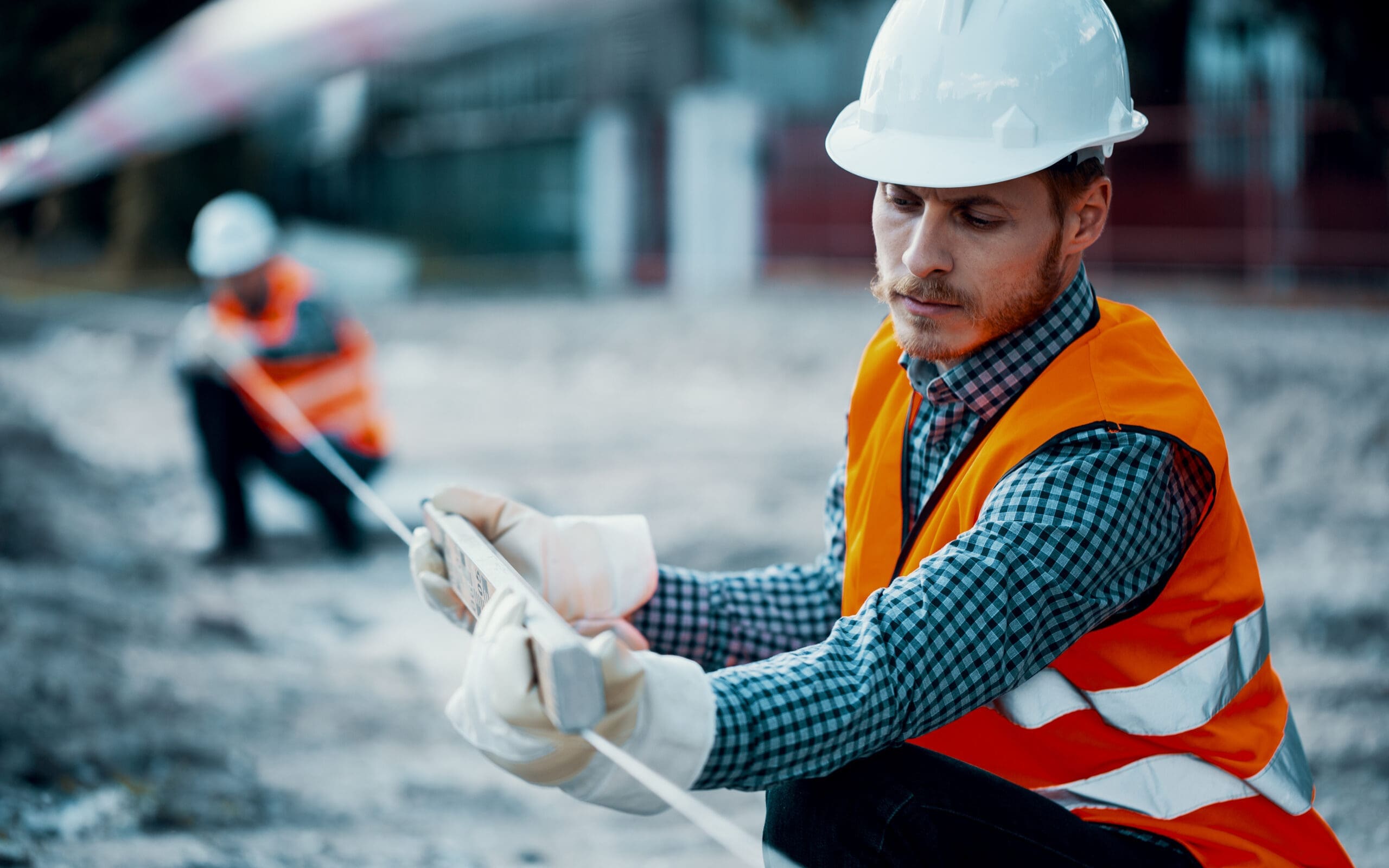 Worker in Orange Uniform and white helmet practicing safety during roadworks.